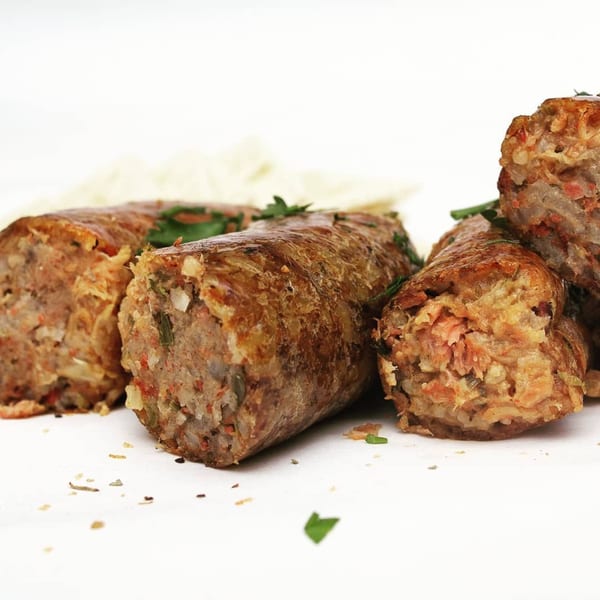 Close-up of three Cajun boudin sausages, one cut open to reveal the savory filling.